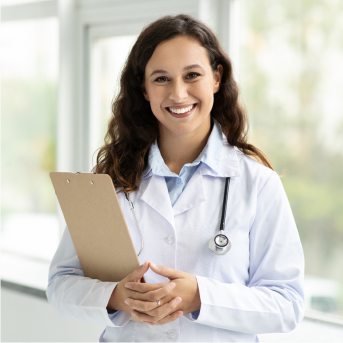 eine Ärztin die lächelt und direkt in die Kamera schaut